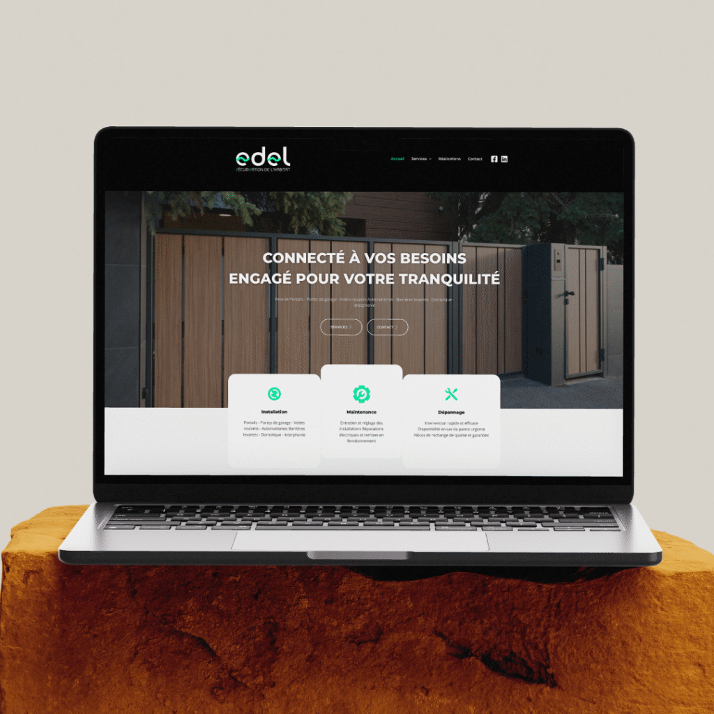 Un ordinateur portable montrant la page d’accueil du site internet de l’entreprise Edel Sécurisation de l’habitat. On découvre un bandeau noir pour le header, avec le logo EDEL sur la gauche, et la navbarre à droite, accompagné des raccourcis pour les réseaux sociaux. En bannière héroïque, une image de portail avec la phrase d’accroche « Connecté à vos besoins, engagé pour votre tranquillité ». À cheval sur la bannière héroïque et la suite de la page, trois blocs représentant les grands axes de services de l’entreprise : l’installation, la maintenance et le dépannage.